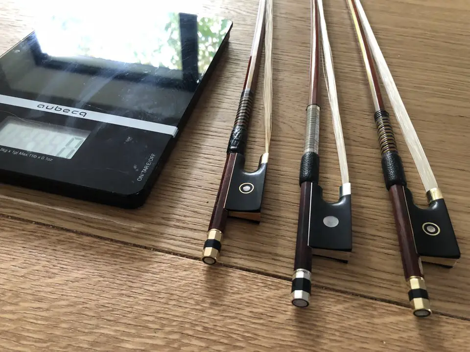 different types of violin bows on a scale